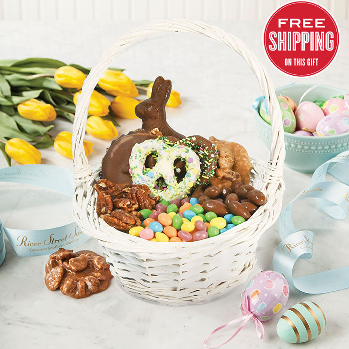 A Easter basket filled with various candies and chocolate items, with a decorative chocolate bunny and Easter eggs visible. The basket is set against a backdrop of yellow tulips, with a 'Free Shipping' text overlay at the top.