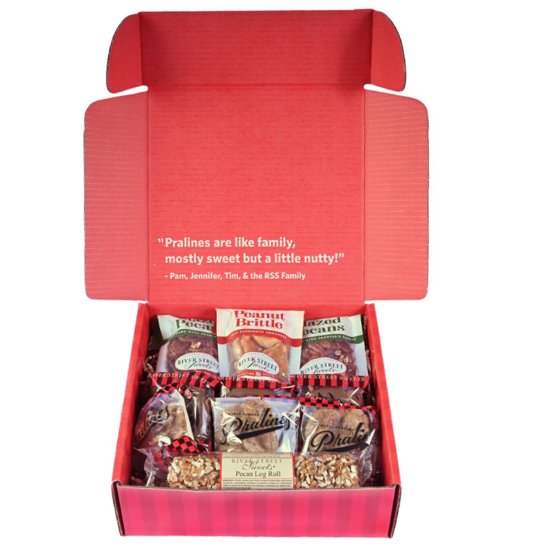 Assorted candies in a red box with the lid open on a white background