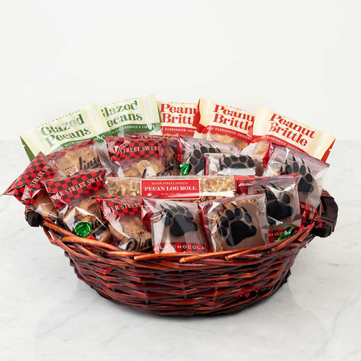Basket of assorted sweet treats with visible packaging on a white background