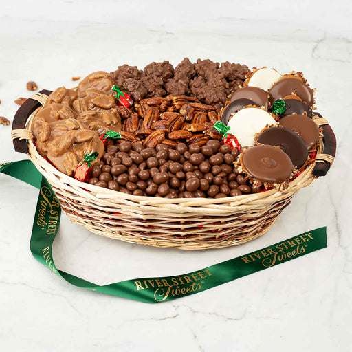 Wicker basket filled with assorted chocolates and candies, branded 'River Street Sweets', on a white background.