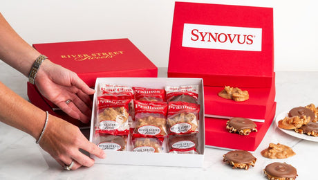 Hands reaching for a box with custom logo boxes in the background