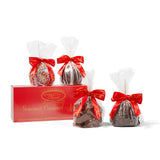 Gourmet caramel apples with red ribbons in front of a River Street Sweets box on a white background