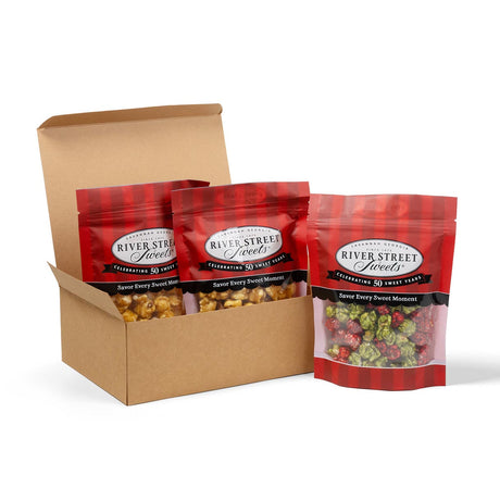 Box of River Street Sweets bags with red and black plaid design on a white background