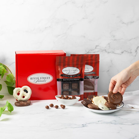 River Street Sweets chocolates on a plate with a red gift box and packaging in the background.