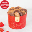 A red container filled with chocolate covered bear claws and pralines. The container has 'River Street Sweets' branding on it.