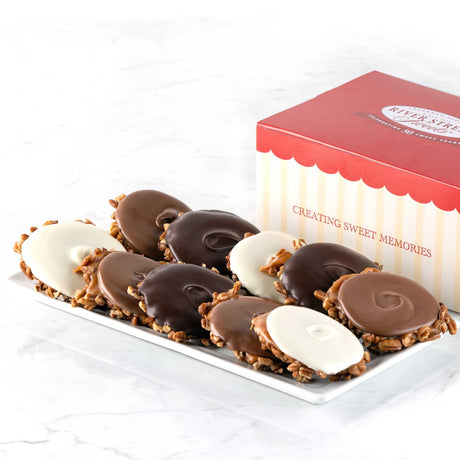 A box of assorted bear claws candies with chocolate and caramel toppings, presented on a white plate with a red and white box in the background.
