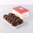 A box of dark chocolate bear claws candies displayed on a white plate with the box