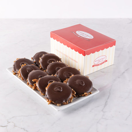 A box of dark chocolate bear claws candies displayed on a white plate with the box