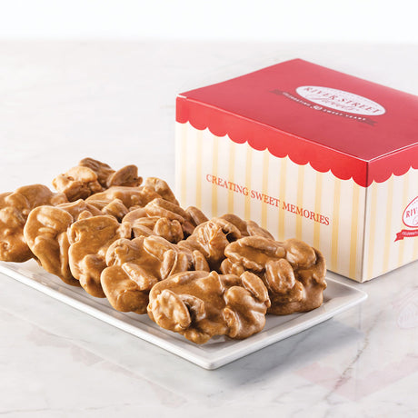A box of Savannah's World Famous Pralines with the text 'CREATING SWEET MEMORIES' on the box. The pralines are displayed in front of the box on a white plate.