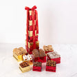 A gift tower featuring an assortment of chocolate treats including bear claws, pralines, chocolate almonds, and pecans, packaged in red and gold boxes.