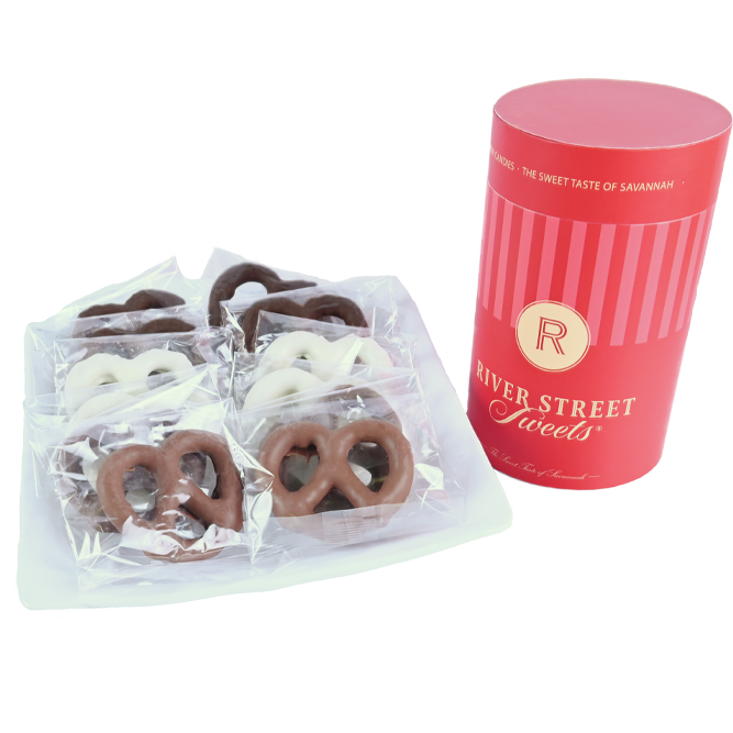 Packaged assorted pretzels on a white plate beside a red canister