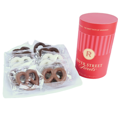 Packaged assorted pretzels on a white plate beside a red canister