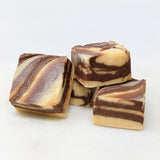 Squares of peanut butter chocolate swirl fudge on a white background.