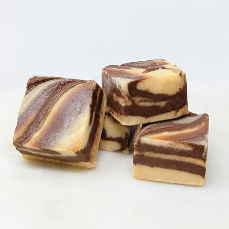 Squares of peanut butter chocolate swirl fudge on a white background.