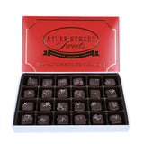 Dark chocolate sea salt caramels in a white box with the red lid propped up behind
