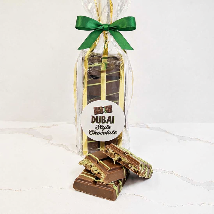 Packaged chocolate bars with a green ribbon on a white background
