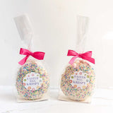 Two Easter egg-shaped Krispy treats in clear bags with pink ribbons on a white background.