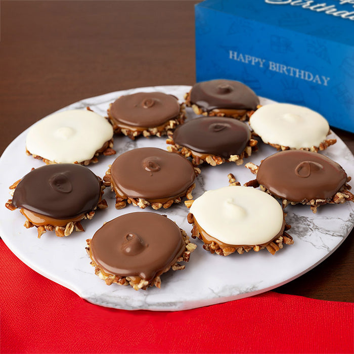 Assorted chocolate bear claws on a marble plate with a 'Happy Birthday' box in the background.
