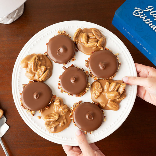 Plate of chocolate bear claws and pralines with a 'Happy Birthday' box in the background
