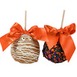 Two decorated apples with orange ribbons on a white background