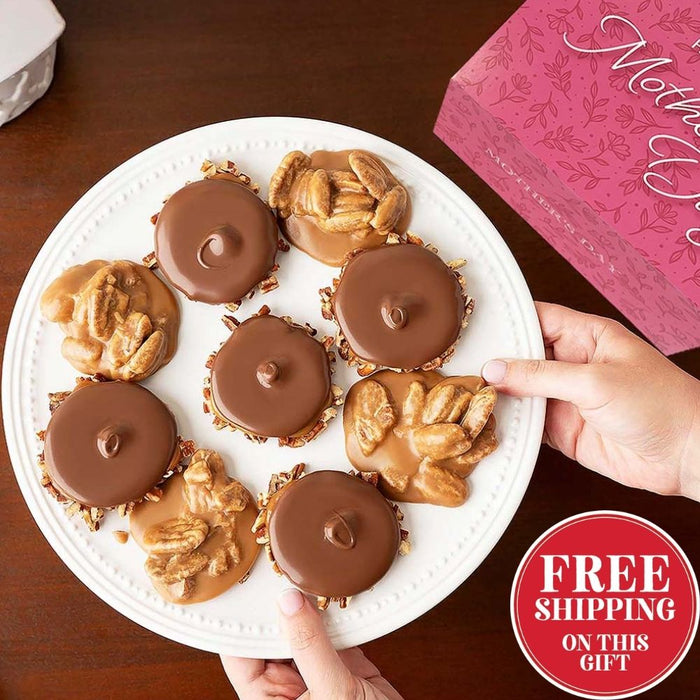 Bear claws and pralines on a white plate with a hand reaching for one, and a pink box in the background.