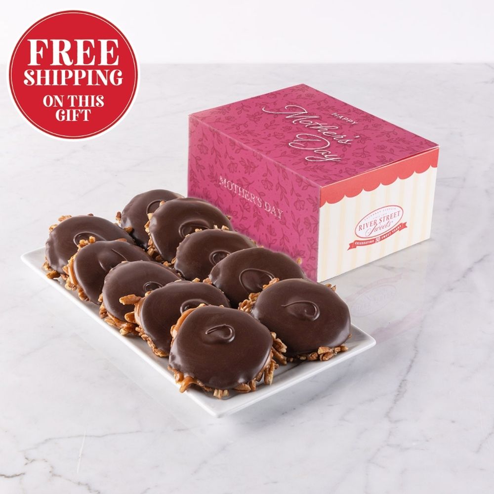 Bear claws on a plate with a pink gift box labeled 'Mother's Day' on a marble surface.