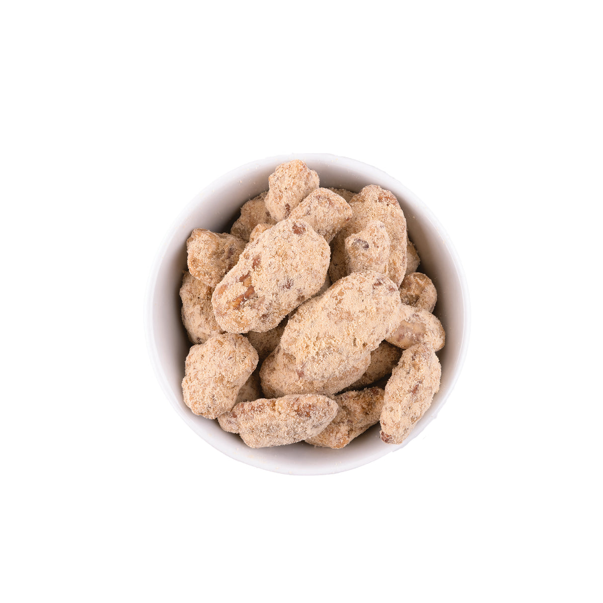 Praline pecans in a white bowl on a white backround