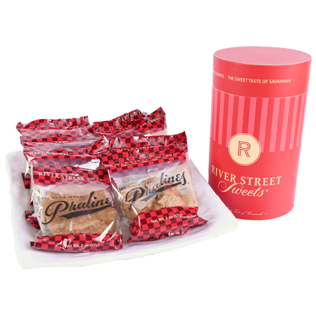 Packaged Pralines on a plate beside a red "River Street Sweets." canister