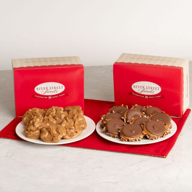 Two red boxes of River Street Sweets candy. One plate holds pralines, and the other holds bear claws