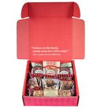 Assorted candies in a red box with the lid open on a white background