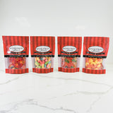 Four packages of River Street Sweets on a white marble surface