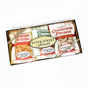 A gift box containing three types of nut products: Glazed Pecans, Peanut Brittle, and Cinnamon Pecans, from River Street Sweets.