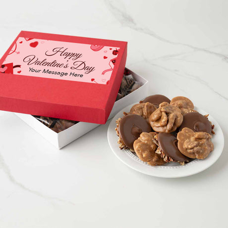 Valentine's Day themed chocolate candy box with a plate of chocolates and pralines on a white surface