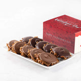 Chocolate bear claws on a white plate with a 'Happy Valentine's Day' box in the background.