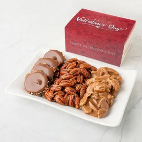 Bear Claws, glazed pecans, and pralines on a plate with a Valentine's Day box in the background.