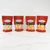 Four bags of River Street Sweets popcorn on a white background