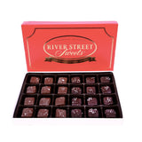 Milk and dark chocolate caramels in a white box with the red lid propped up behind