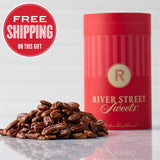 A red cylindrical canister labeled 'River Street Sweets' with a pile of glazed pecans in front of it. There is a 'Free Shipping' text overlay at the top left of the image.