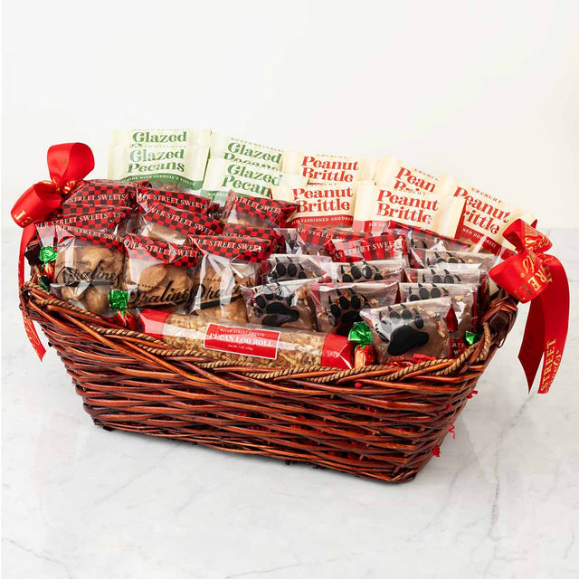 Gift basket with assorted treats including peanut brittle and glazed pecans on a white background