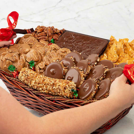 Basket of assorted snacks including pralines, chocolate, and nuts on a white surface.