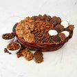 Basket of assorted chocolate-covered treats including bear claws and pecans on a white marble surface.