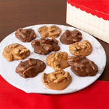 Assorted pralines on a white plate with a red box in the background.