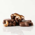 Chocolate-covered cashews on a white background