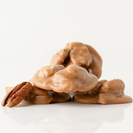 Pecan pralines on a white surface with a white background