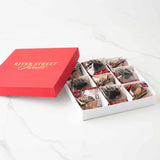 Red 'River Street Sweets' box with a white interior containing chocolate bear claws and pralines