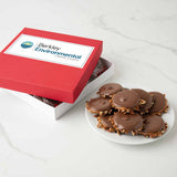 Red box with a custom logo and a plate of chocolate bear claws on a white surface