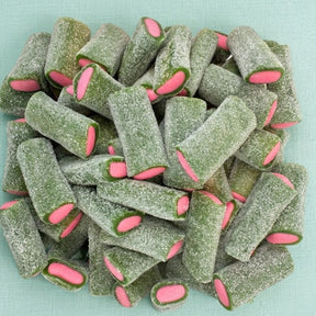 A pile of green, sugar-dusted cylindrical candy pieces with bright pink oval centers, arranged on a light aqua background.