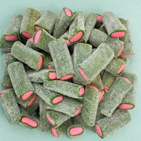 A pile of green, sugar-dusted cylindrical candy pieces with bright pink oval centers, arranged on a light aqua background.