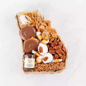 A gift basket containing an assortment of sweet treats including chocolate covered nuts, pralines, and other Georgia-themed snacks.